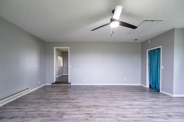 13216 Sheley Road Nw, Jeffersonville, OH 43128 - spare room featuring attic access, baseboard heating, wood finished floors, and a ceiling fan