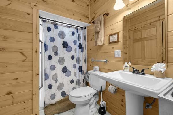 29002 Rockstull Rd, Sugar Grove, OH 43155 - bathroom featuring wooden walls, toilet, and curtained shower