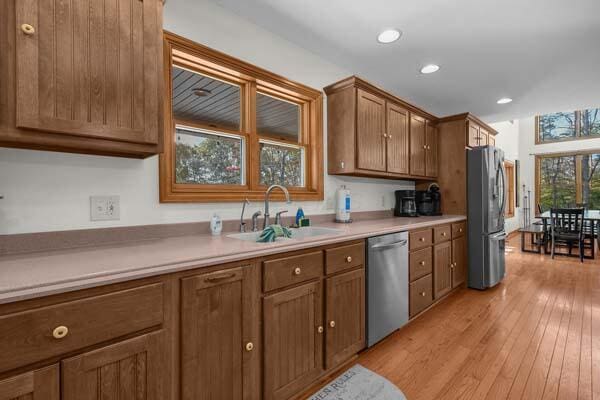 29002 Rockstull Rd, Sugar Grove, OH 43155 - kitchen featuring stainless steel appliances, a sink, light wood-type flooring, light countertops, and brown cabinetry