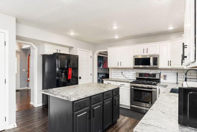 7936 Slate Ridge Blvd, Reynoldsburg, OH 43068 - kitchen with appliances with stainless steel finishes, white cabinets, backsplash, dark cabinetry, and recessed lighting