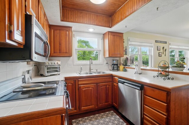 5336 Rocky Creek Dr, Grove City, OH 43123 - kitchen featuring appliances with stainless steel finishes, a sink, a peninsula, tile counters, and plenty of natural light