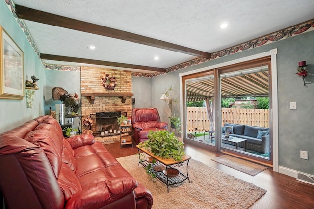5336 Rocky Creek Dr, Grove City, OH 43123 - living area featuring wood finished floors, beamed ceiling, a textured ceiling, baseboards, and a brick fireplace