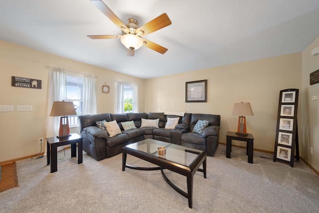 living area with a ceiling fan, baseboards, and light carpet