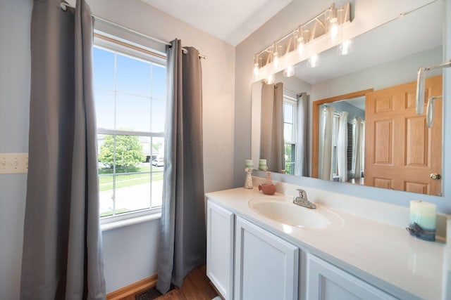 bathroom featuring healthy amount of natural light, vanity, and wood finished floors