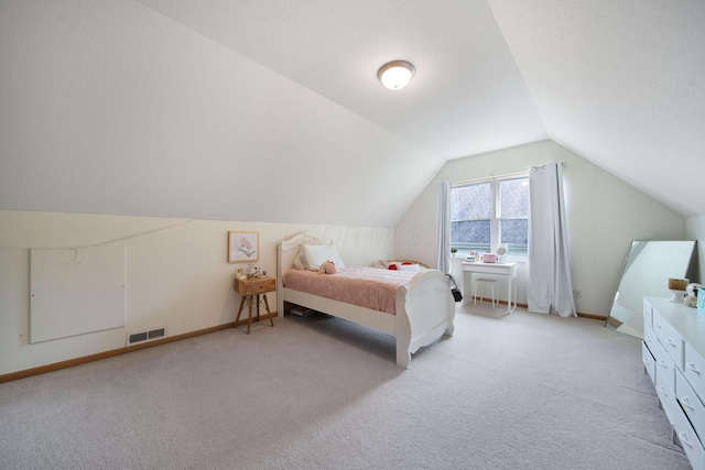 bedroom featuring light carpet, lofted ceiling, and baseboards