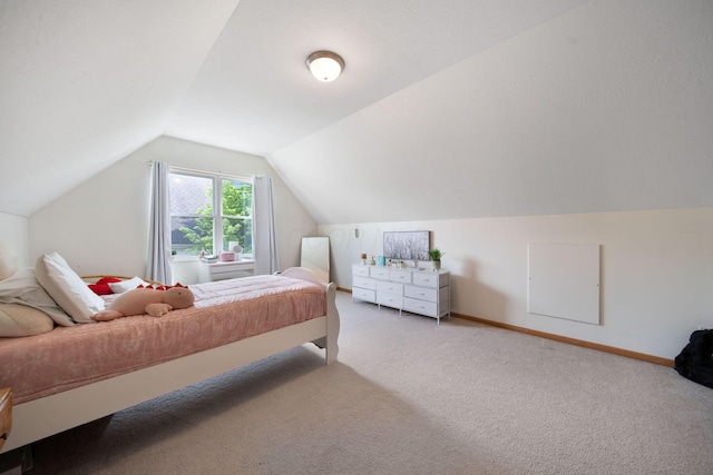 carpeted bedroom featuring vaulted ceiling and baseboards