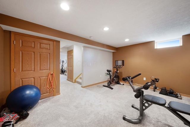 exercise area with baseboards, light carpet, and recessed lighting