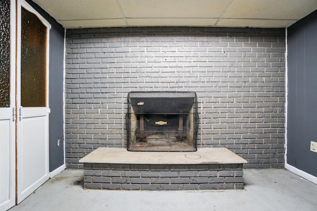 700 Taylor Blair Rd, West Jefferson, OH 43162 - detailed view of concrete floors, baseboards, a drop ceiling, and a brick fireplace