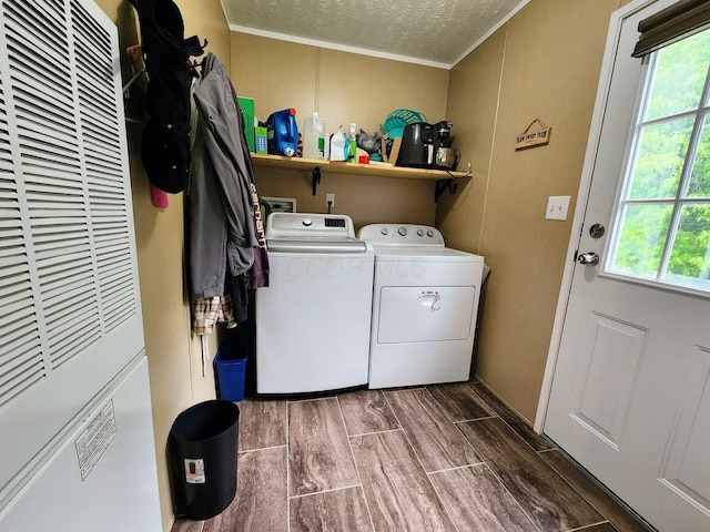 clothes washing area featuring a heating unit, independent washer and dryer, crown molding, plenty of natural light, and a textured ceiling