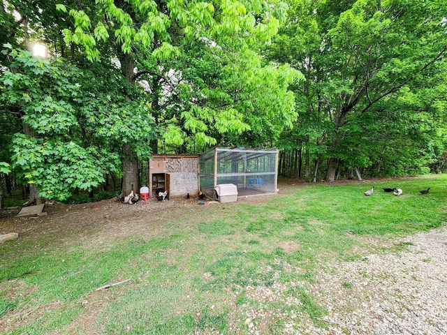 view of grassy yard featuring exterior structure and an outdoor structure