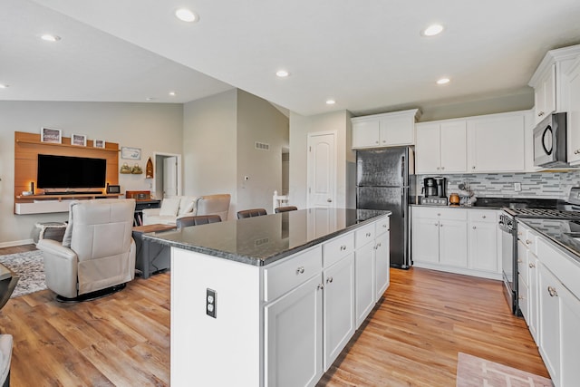 6922 Duke Dr, Canal Winchester, OH 43110 - kitchen with appliances with stainless steel finishes, vaulted ceiling, a kitchen island, light wood-type flooring, and open floor plan