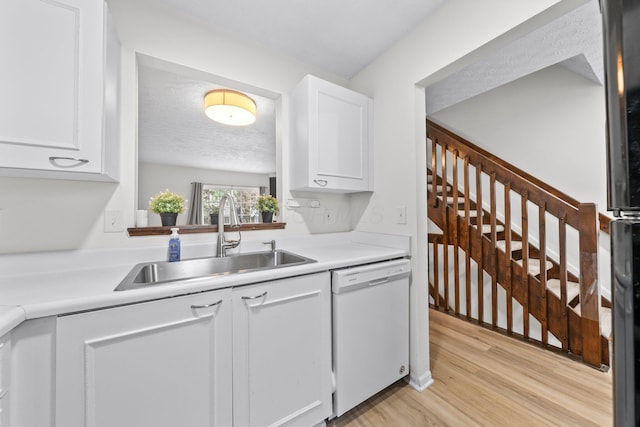 1733 Messner Dr Unit 151D, Hilliard, OH 43026 - kitchen with a sink, white dishwasher, white cabinets, light wood-style flooring, and a textured ceiling
