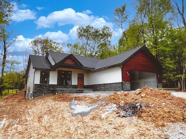 561 Crestmonte Dr, Howard, OH 43028 - view of front of home with stone siding, a garage, and a shingled roof