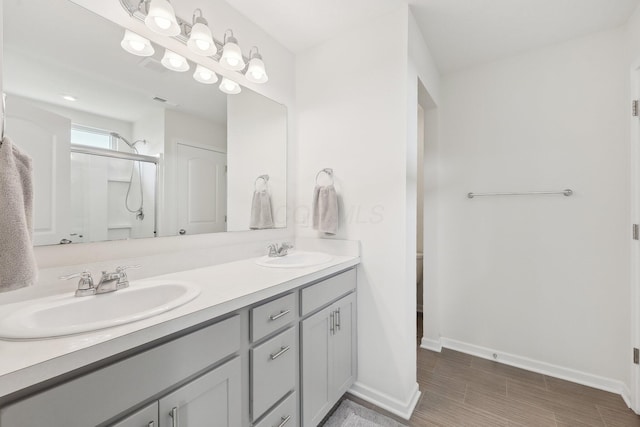 3321 Butternut Ln, Hebron, OH 43025 - full bath featuring a stall shower, double vanity, baseboards, and wood finished floors