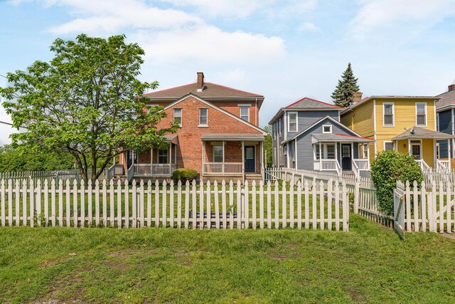 684 Hamlet St, Columbus, OH 43215 - view of front facade featuring covered porch, brick siding, and a chimney