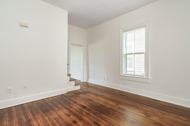 684 Hamlet St, Columbus, OH 43215 - unfurnished room with baseboards, dark wood finished floors, and stairs
