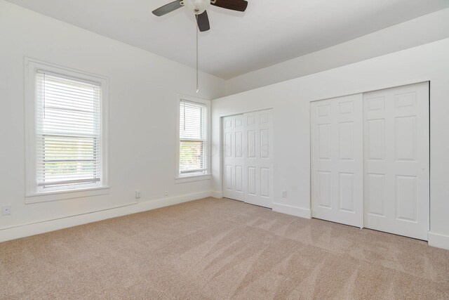 684 Hamlet St, Columbus, OH 43215 - unfurnished bedroom featuring multiple closets, light carpet, and multiple windows