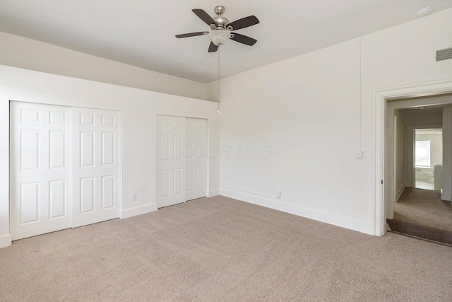 684 Hamlet St, Columbus, OH 43215 - unfurnished bedroom featuring carpet, multiple closets, baseboards, and ceiling fan