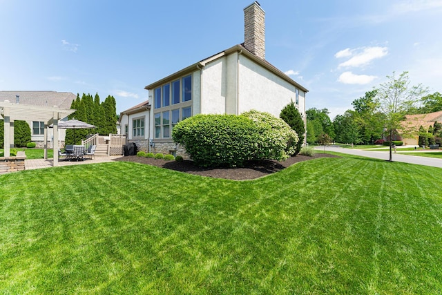 1338 Elkhorn Dr, Blacklick, OH 43004 - view of home's exterior featuring a chimney, a lawn, stucco siding, and a patio area