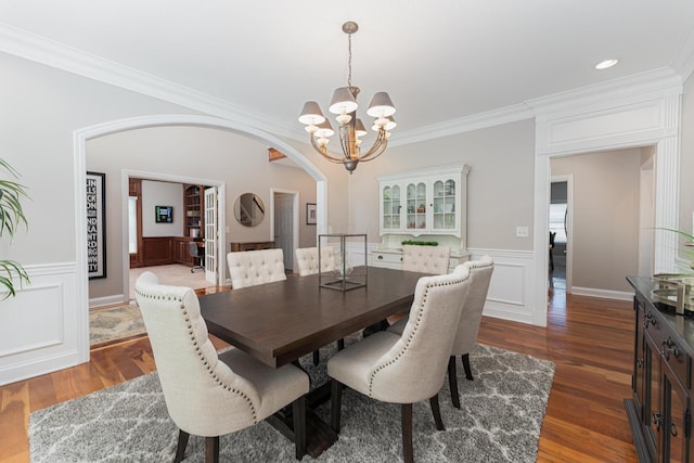 1338 Elkhorn Dr, Blacklick, OH 43004 - dining space featuring arched walkways, a chandelier, dark wood-style flooring, ornamental molding, and a wainscoted wall