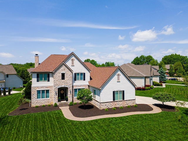 1338 Elkhorn Dr, Blacklick, OH 43004 - view of front of home with stone siding, stucco siding, a chimney, and a front yard