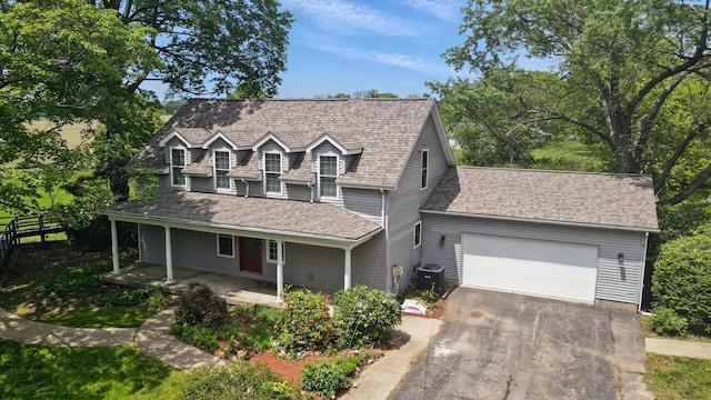 9820 Heimberger Rd NW, Baltimore, OH 43105 - view of front of home with fence, a garage, asphalt driveway, covered porch, and central air condition unit