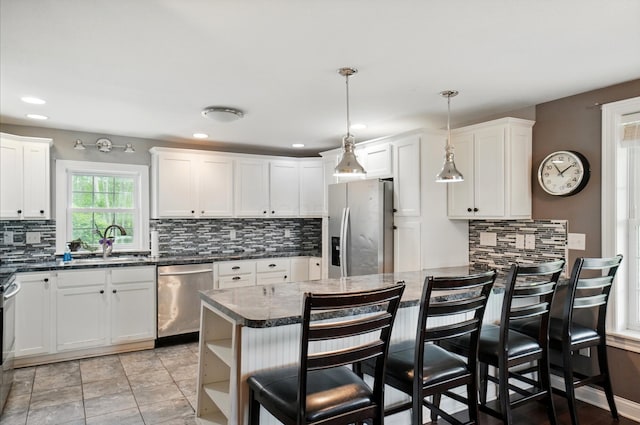 9820 Heimberger Rd NW, Baltimore, OH 43105 - kitchen featuring stainless steel appliances, a sink, backsplash, a kitchen bar, and white cabinets