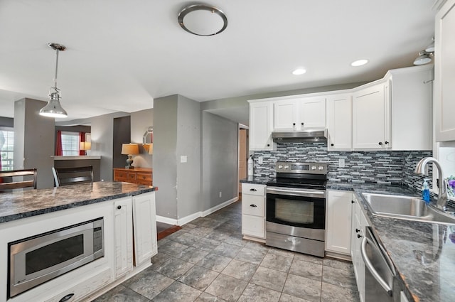 9820 Heimberger Rd NW, Baltimore, OH 43105 - kitchen featuring appliances with stainless steel finishes, a sink, decorative backsplash, white cabinetry, and baseboards