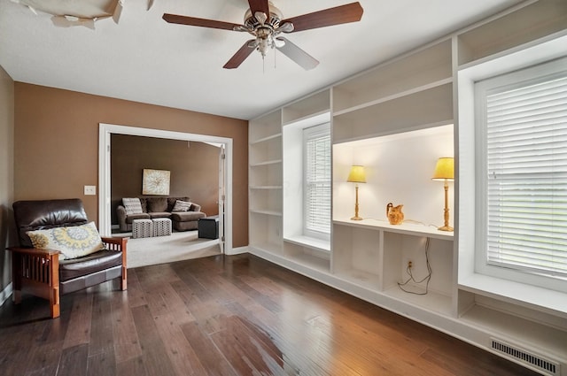 9820 Heimberger Rd NW, Baltimore, OH 43105 - sitting room featuring dark wood-style floors, built in features, a ceiling fan, and plenty of natural light
