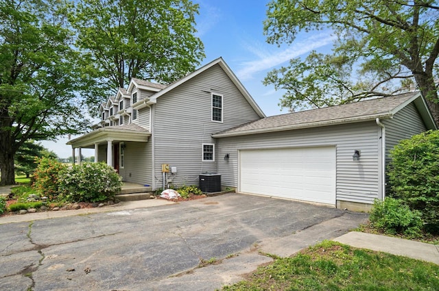9820 Heimberger Rd NW, Baltimore, OH 43105 - view of front of property featuring asphalt driveway, a garage, central AC, and a shingled roof