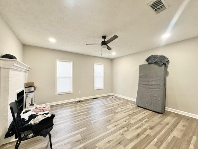 2624 Osceola Ave, Columbus, OH 43211 - living room featuring a ceiling fan, light wood-style flooring, a brick fireplace, baseboards, and recessed lighting