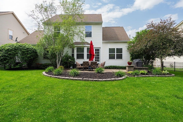 rear view of house featuring a patio and roof with shingles