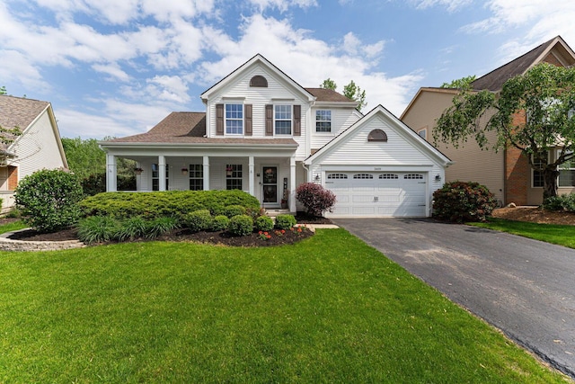 view of front of house with driveway, a front lawn, a garage, and a porch