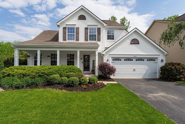 view of front of house with asphalt driveway, a front lawn, covered porch, a shingled roof, and an attached garage
