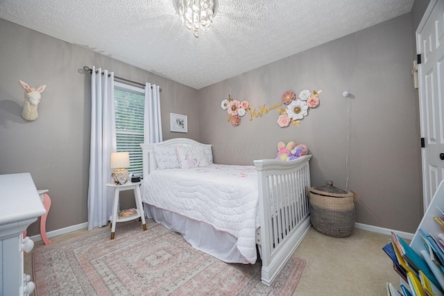 3409 Marl Pl, Columbus, OH 43221 - carpeted bedroom with a textured ceiling, baseboards, and a chandelier