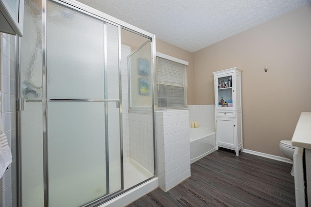 3409 Marl Pl, Columbus, OH 43221 - bathroom with wood finished floors, a garden tub, toilet, a shower stall, and a textured ceiling
