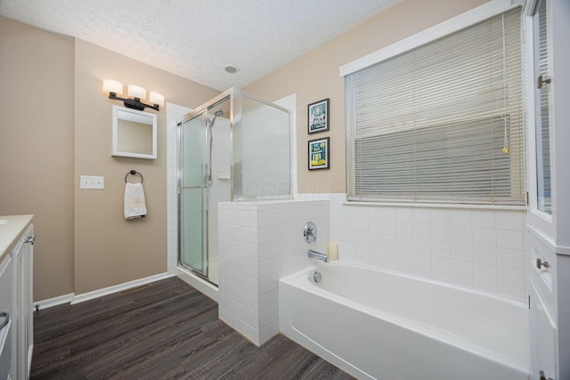 3409 Marl Pl, Columbus, OH 43221 - full bathroom featuring a bath, wood finished floors, a shower stall, vanity, and a textured ceiling