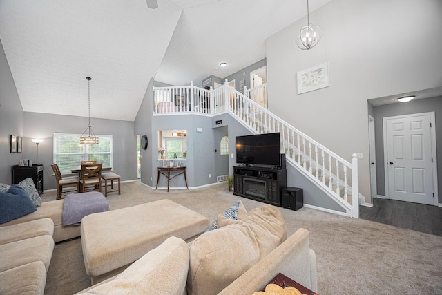 3409 Marl Pl, Columbus, OH 43221 - living room featuring high vaulted ceiling, carpet floors, a chandelier, stairs, and baseboards