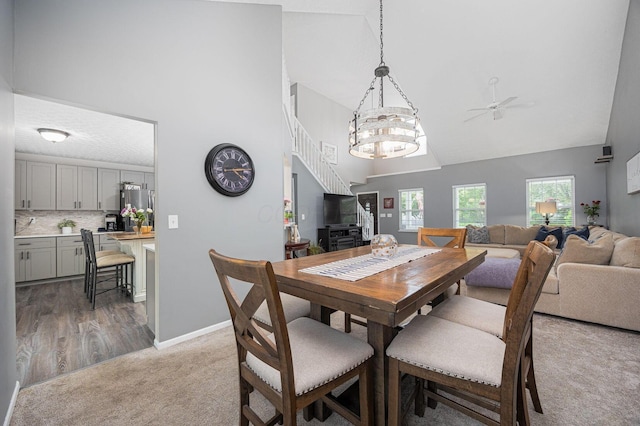 3409 Marl Pl, Columbus, OH 43221 - dining space featuring high vaulted ceiling, ceiling fan, light colored carpet, baseboards, and stairs