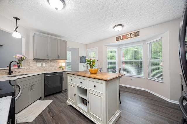 3409 Marl Pl, Columbus, OH 43221 - kitchen featuring stainless steel dishwasher, a sink, dark wood finished floors, gray cabinetry, and backsplash