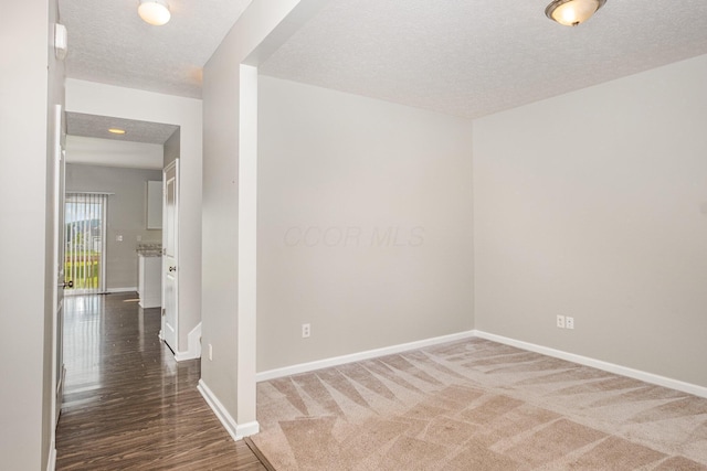 2357 Pine Crest Dr, Lancaster, OH 43130 - carpeted empty room with a textured ceiling, baseboards, and wood finished floors