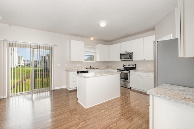 2357 Pine Crest Dr, Lancaster, OH 43130 - kitchen with stainless steel appliances, wood finished floors, a kitchen island, and white cabinets