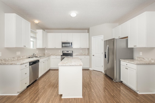 2357 Pine Crest Dr, Lancaster, OH 43130 - kitchen featuring appliances with stainless steel finishes, a kitchen island, wood finished floors, a sink, and white cabinetry
