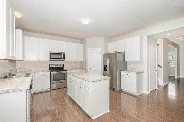 2357 Pine Crest Dr, Lancaster, OH 43130 - kitchen with stainless steel appliances, a sink, a kitchen island, and wood finished floors