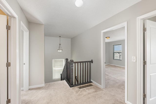 2357 Pine Crest Dr, Lancaster, OH 43130 - hallway featuring an upstairs landing, light carpet, baseboards, and a textured ceiling