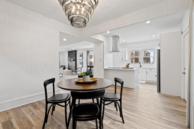 1104 E Whittier St, Columbus, OH 43206 - dining room with light wood-style floors, a chandelier, recessed lighting, and baseboards