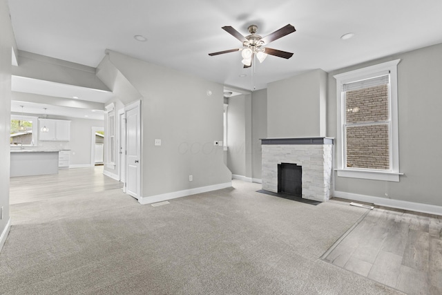 1093 E Long St, Columbus, OH 43203 - unfurnished living room featuring a ceiling fan, a fireplace, baseboards, recessed lighting, and light colored carpet