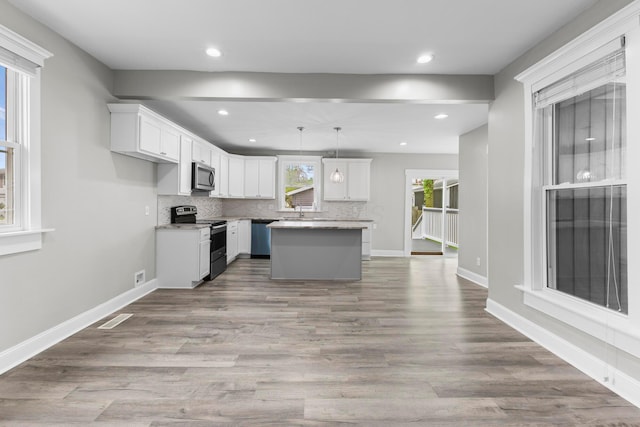 1093 E Long St, Columbus, OH 43203 - kitchen featuring stainless steel appliances, tasteful backsplash, white cabinets, wood finished floors, and recessed lighting