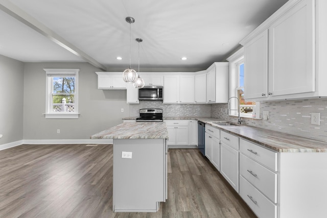 1093 E Long St, Columbus, OH 43203 - kitchen with appliances with stainless steel finishes, a sink, baseboards, decorative backsplash, and dark wood-style flooring