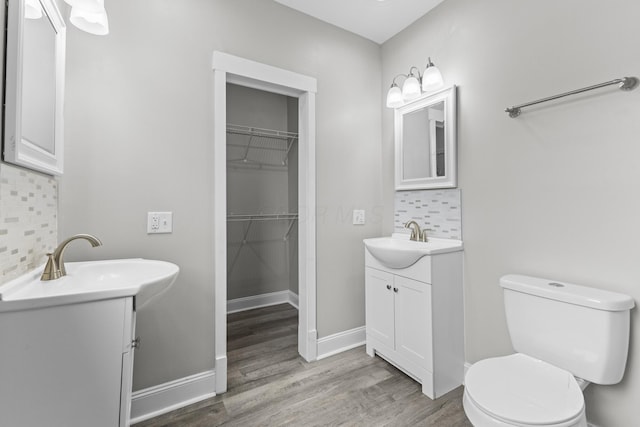 1093 E Long St, Columbus, OH 43203 - bathroom with decorative backsplash, wood finished floors, toilet, two vanities, and a spacious closet